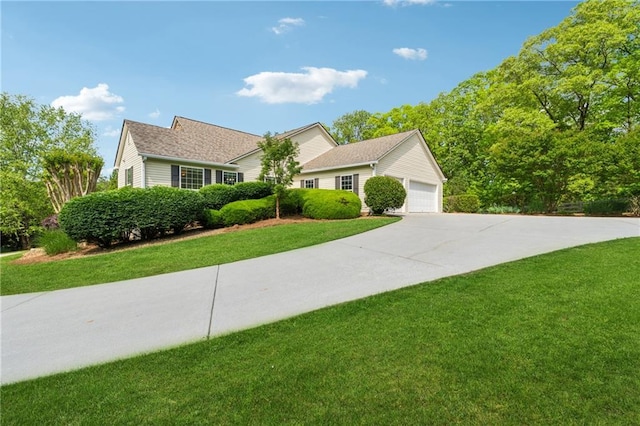view of front facade featuring an attached garage, driveway, and a front yard