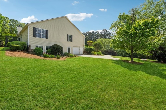view of side of property with a garage, a lawn, and driveway