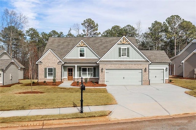 craftsman house with driveway, a front lawn, board and batten siding, roof with shingles, and brick siding