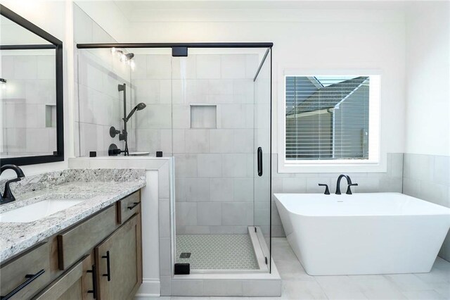 bathroom with a soaking tub, a shower stall, and vanity