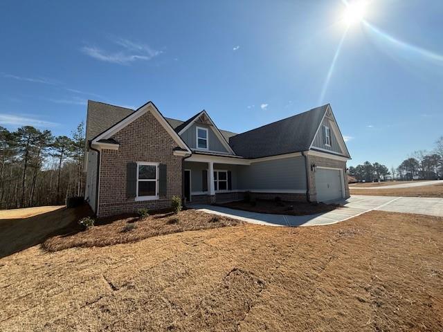 view of front of house featuring a garage, covered porch, and brick siding