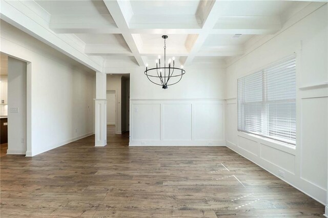 unfurnished dining area featuring wood finished floors, beam ceiling, a chandelier, and a decorative wall