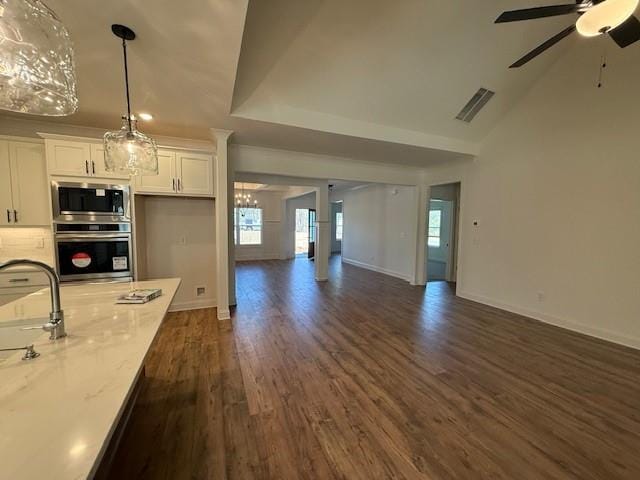 kitchen featuring stainless steel appliances, dark wood-type flooring, visible vents, white cabinetry, and open floor plan