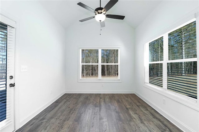 spare room featuring dark wood finished floors, a ceiling fan, baseboards, and vaulted ceiling