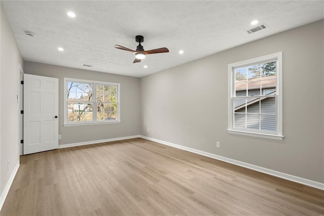 spare room with light wood-style floors, baseboards, and ceiling fan