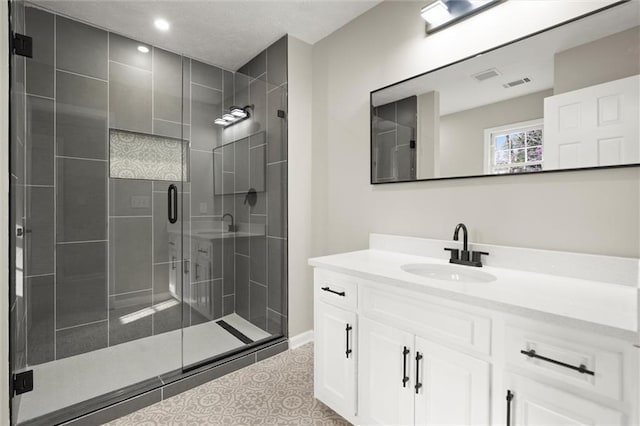 bathroom featuring visible vents, a stall shower, vanity, and tile patterned flooring