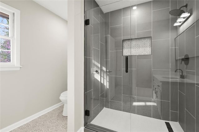 full bathroom with a stall shower, toilet, baseboards, and a sink