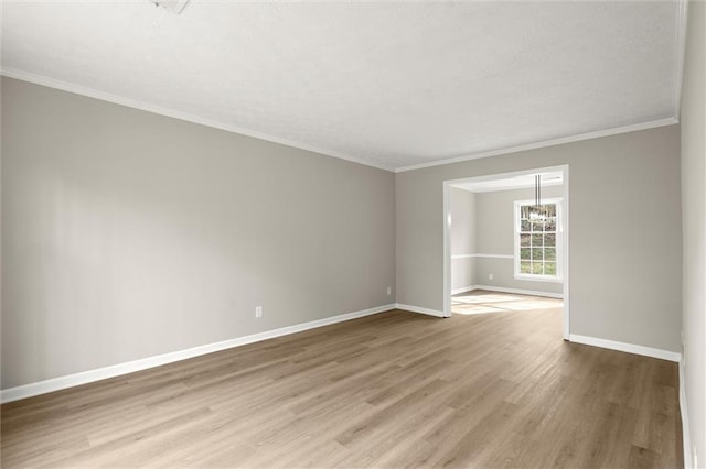 unfurnished room featuring baseboards, a textured ceiling, light wood-style flooring, and ornamental molding