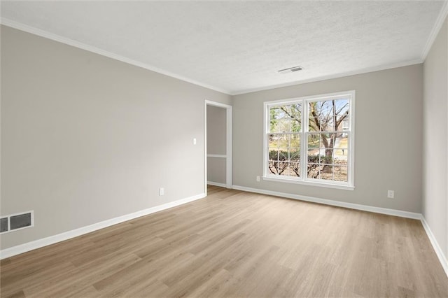 unfurnished room featuring light wood finished floors, visible vents, baseboards, and ornamental molding