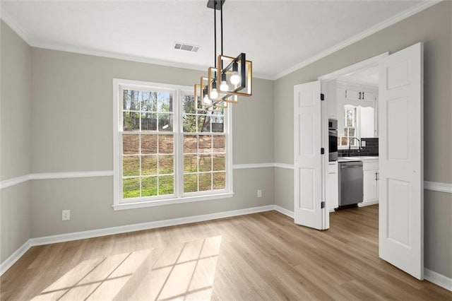 unfurnished dining area featuring baseboards, visible vents, light wood-style flooring, a sink, and a chandelier