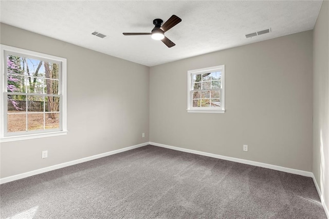 empty room featuring baseboards, visible vents, carpet floors, ceiling fan, and a textured ceiling