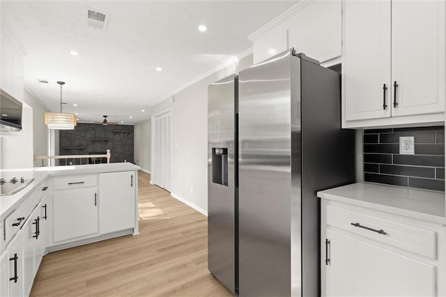 kitchen featuring tasteful backsplash, visible vents, stainless steel fridge with ice dispenser, ornamental molding, and white cabinets