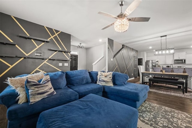 living room with ceiling fan and dark hardwood / wood-style flooring