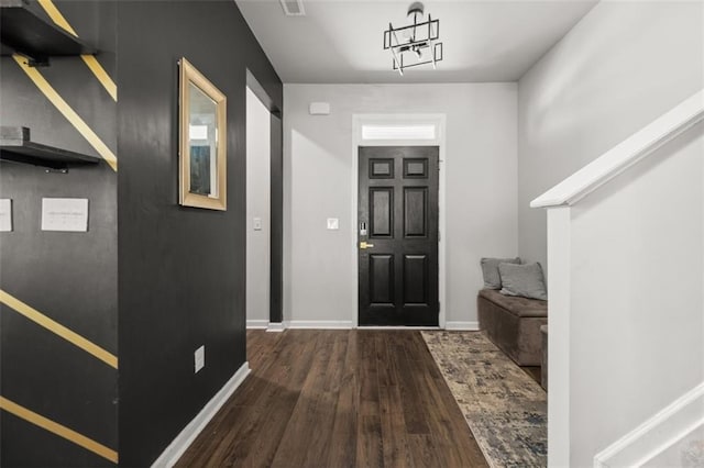 foyer featuring dark wood-type flooring and a notable chandelier