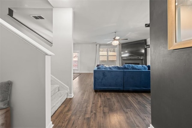 living room with dark hardwood / wood-style floors and ceiling fan