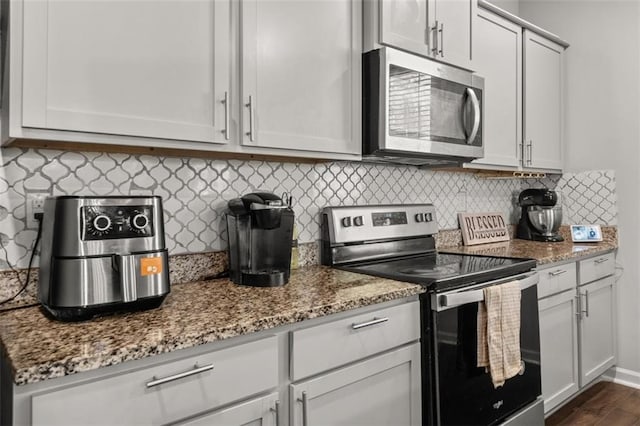 kitchen with light stone counters, white cabinets, and appliances with stainless steel finishes