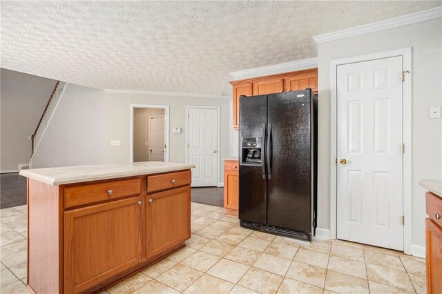 kitchen with light tile patterned floors, a center island, crown molding, black fridge with ice dispenser, and a textured ceiling