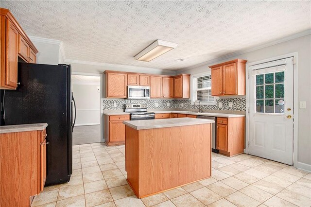 kitchen featuring a textured ceiling, crown molding, a center island, stainless steel appliances, and sink