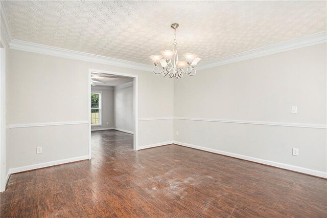 empty room featuring dark wood-type flooring, an inviting chandelier, a textured ceiling, and ornamental molding