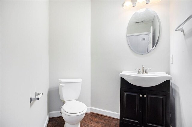 bathroom with vanity, toilet, and wood-type flooring