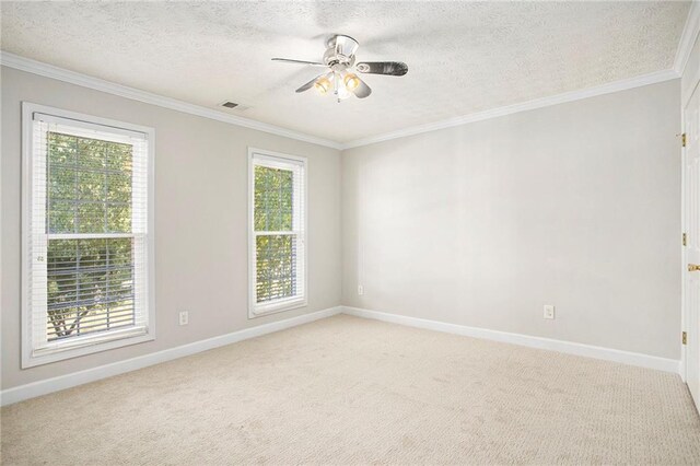 carpeted empty room with ceiling fan, crown molding, and a textured ceiling