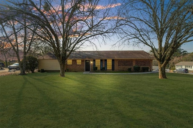 back house at dusk with a lawn