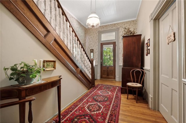 foyer entrance featuring light wood-type flooring and crown molding