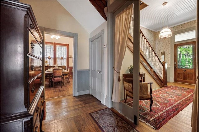 entrance foyer featuring dark wood-type flooring, a chandelier, and plenty of natural light