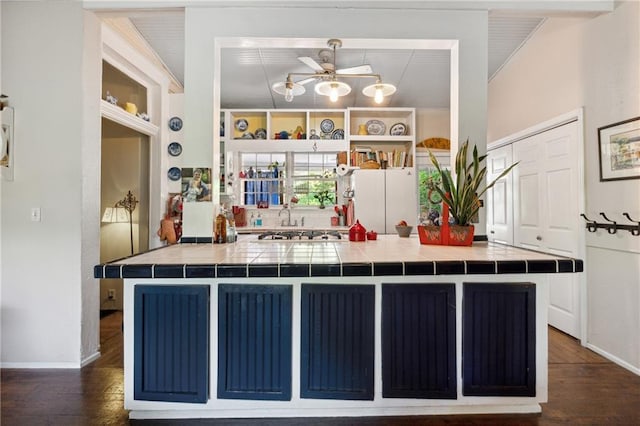 kitchen with dark wood-type flooring, tile counters, and ceiling fan