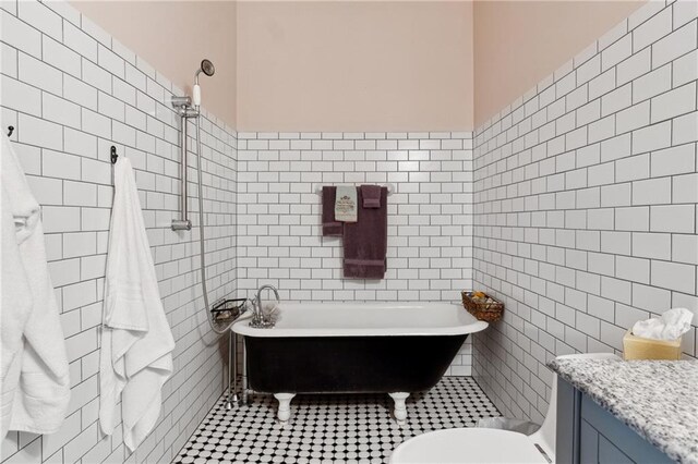 bathroom with toilet, a bathing tub, tile patterned flooring, and tile walls