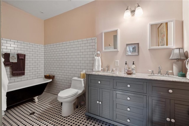 bathroom with toilet, vanity, tile patterned flooring, tile walls, and a tub