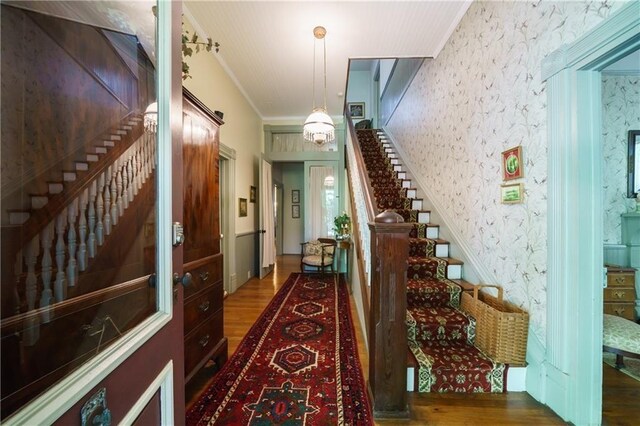 corridor with ornamental molding and dark hardwood / wood-style flooring