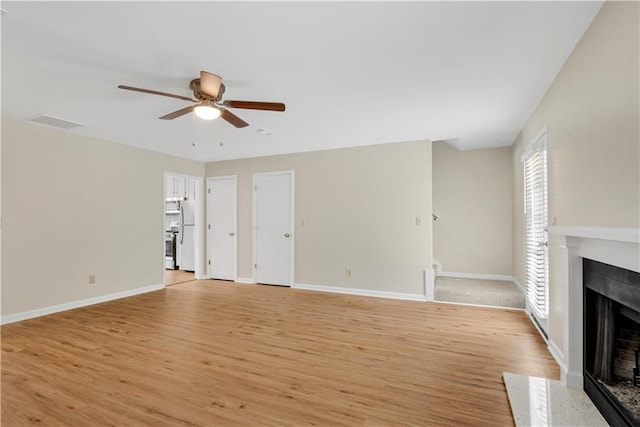 1368 Poplar Pointe SE, Smyrna, GA 30082 - unfurnished living room featuring a fireplace with flush hearth, ceiling fan, light wood finished floors, and baseboards