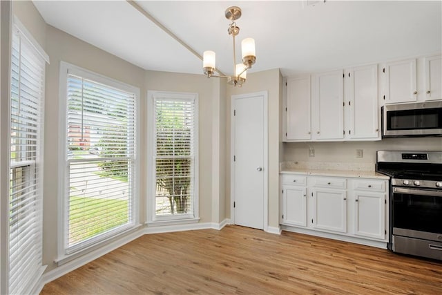 1368 Poplar Pointe SE, Smyrna, GA 30082 - kitchen with stainless steel appliances, white cabinetry, light wood finished floors, and a chandelier