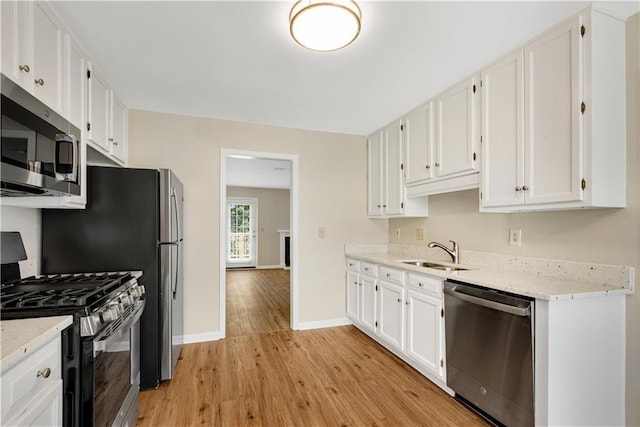 1368 Poplar Pointe SE, Smyrna, GA 30082 - kitchen with appliances with stainless steel finishes, a sink, light wood finished floors, white cabinets, and baseboards