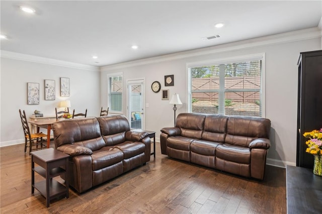 living room featuring ornamental molding, dark hardwood / wood-style floors, and a healthy amount of sunlight