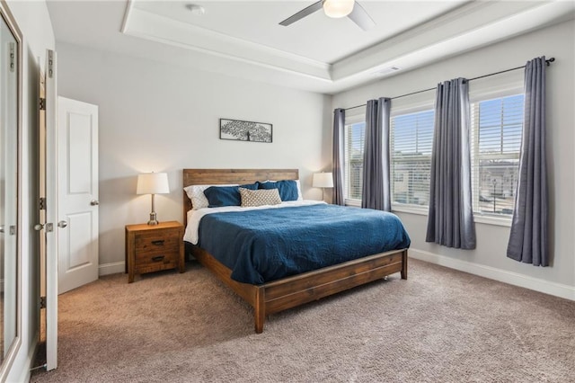 bedroom featuring carpet, ceiling fan, and a tray ceiling