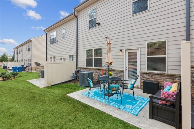 rear view of property with a lawn, a patio, and central air condition unit