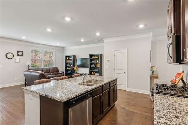 kitchen with sink, crown molding, dark brown cabinets, appliances with stainless steel finishes, and an island with sink