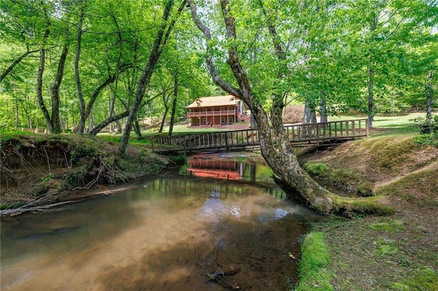 view of community with a water view and a wooded view