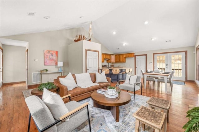 living room featuring french doors, visible vents, light wood-style flooring, and baseboards