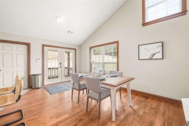 home office featuring french doors, visible vents, high vaulted ceiling, light wood-type flooring, and baseboards