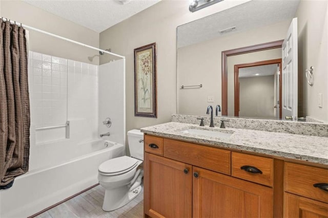 bathroom featuring a textured ceiling, toilet, vanity, visible vents, and  shower combination