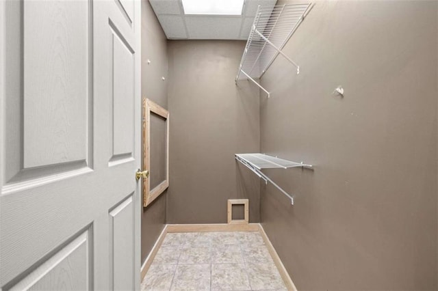 walk in closet with a paneled ceiling and light tile patterned flooring