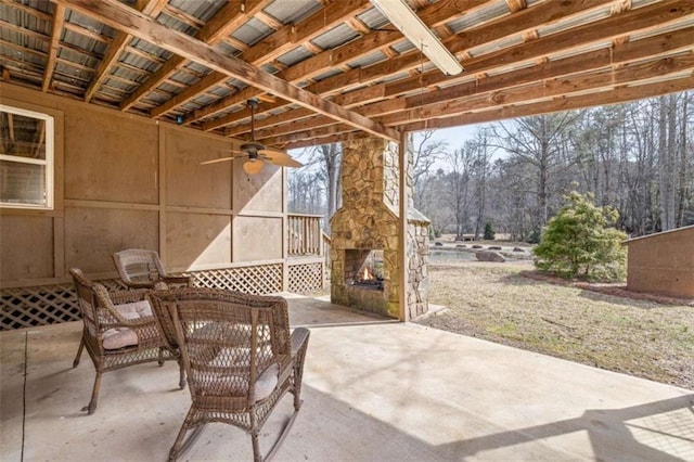 view of patio featuring an outdoor stone fireplace and a ceiling fan