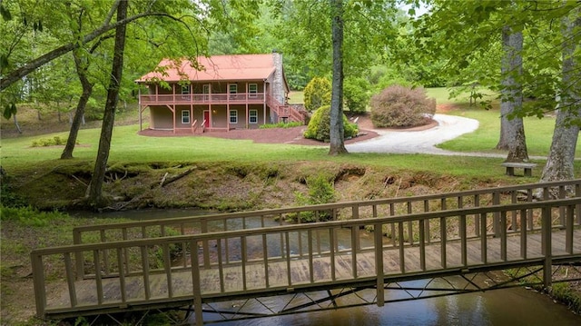 exterior space with stairway and a deck with water view