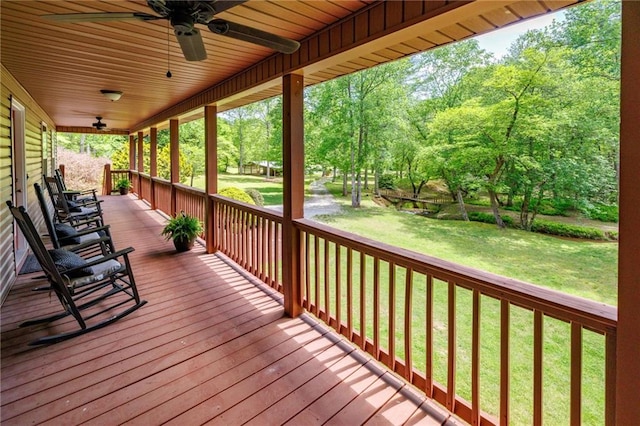 deck with a porch, a lawn, and a ceiling fan