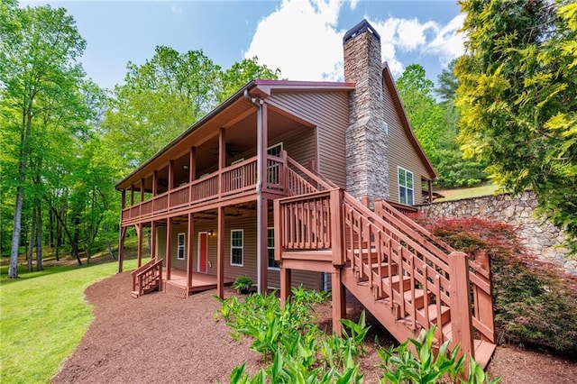 exterior space with a patio, stairs, a lawn, a wooden deck, and a chimney