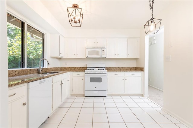 2753 Fireside Ct SE, Marietta, GA 30067 - kitchen with white appliances, a sink, white cabinets, dark stone counters, and pendant lighting