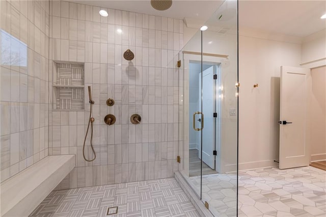 bathroom featuring ornamental molding, tile patterned flooring, and a tile shower